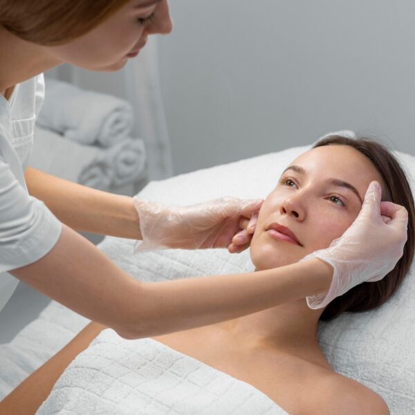 Esteticista aplicando tratamiento facial a clienta en WAM Center | Clínica Estética, promoviendo cuidado profesional.